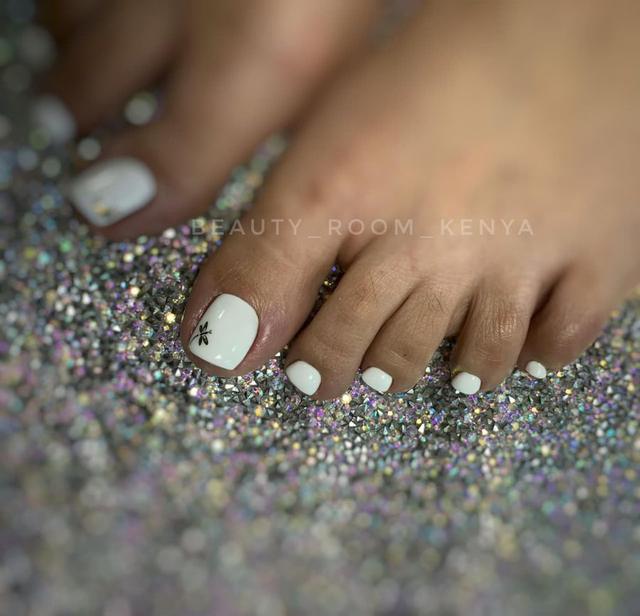 White pedicure with dragonfly accent